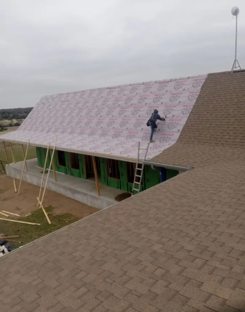 Worker preparing underlayment for a metal roof installation in Lower Burrell